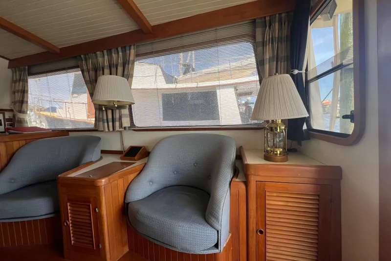 Slide: The Image of Interior of 1989 Hans Christian INDEPENDENCE 45 TRAWLER with wooden table and blue cushioned seating. - 70