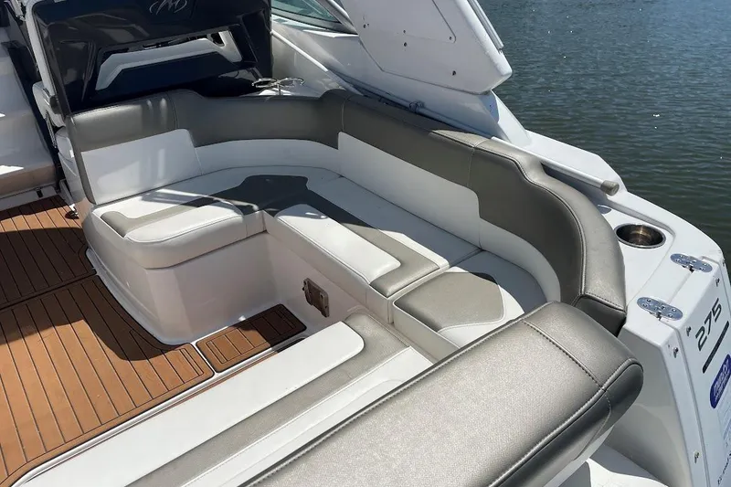 Slide: The Image of 2017 Monterey 275 Sport Yacht interior with cushioned seating and teak flooring by the water. - 22