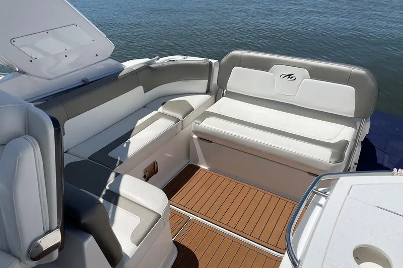 Slide: The Image of 2017 Monterey 275 Sport Yacht interior with cushioned seating and teak flooring. - 23