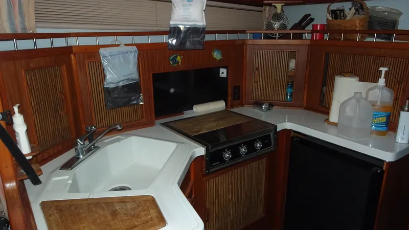 Slide: The Image of 1987 Sea Ray 340 Sundancer kitchen area with sink and stove. - 19