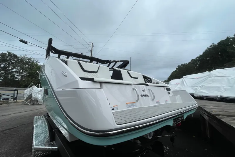 Slide: The Image of 2026 Yamaha Boats 222S, sleek design, rear view, parked outdoors on a trailer. - 2