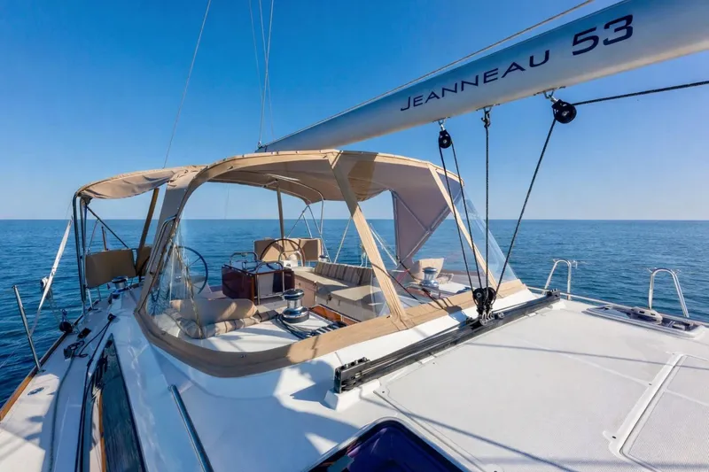 Slide: The Image of 2015 Jeanneau 53 sailboat on open sea, featuring spacious deck and elegant design. - 10