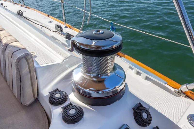 Slide: The Image of 2015 Jeanneau 53 yacht deck with winch and seating, overlooking calm water. - 17