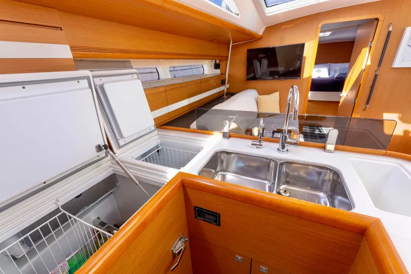 Slide: The Image of Luxurious interior of a 2015 Jeanneau 53 yacht, featuring a modern kitchen design. - 29