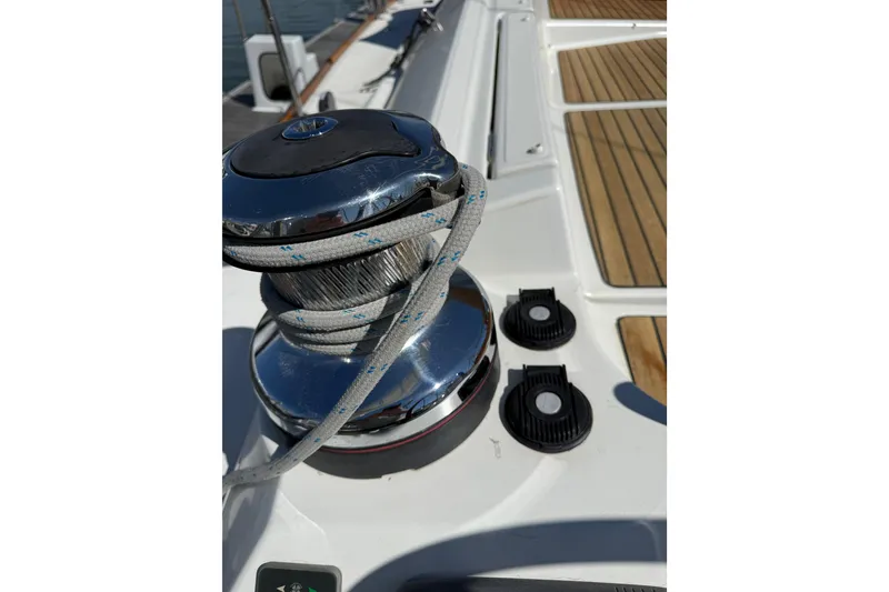 Slide: The Image of Winch on 2015 Jeanneau 53 sailboat deck with rope and teak flooring. - 51