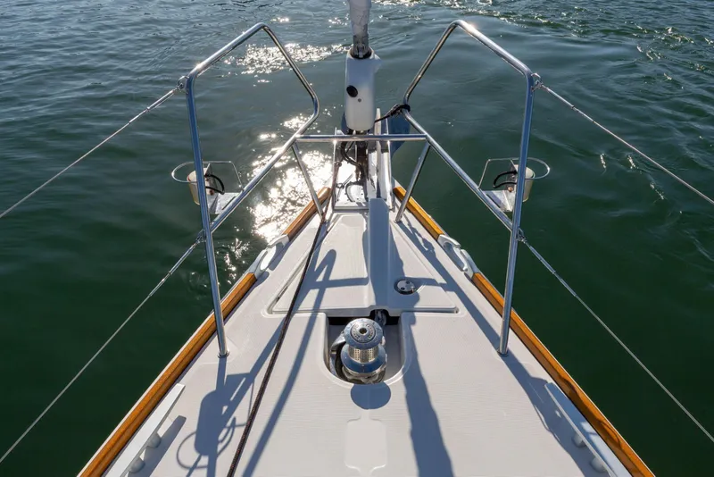 Slide: The Image of Bow of 2015 Jeanneau 53 sailboat on calm water, showcasing deck details. - 7