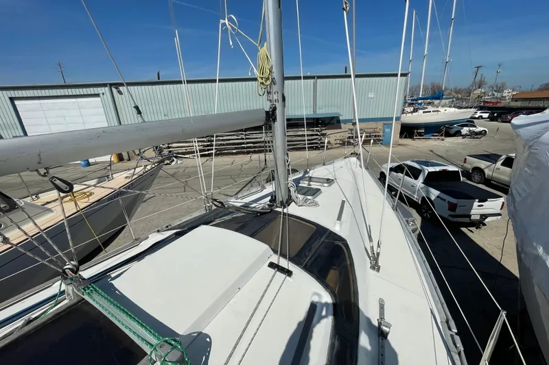 Slide: The Image of 1988 Beneteau Oceanis 350 sailboat docked in a marina, surrounded by vehicles and other boats. - 11