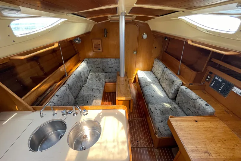 Slide: The Image of Interior of 1988 Beneteau Oceanis 350 sailboat with cozy seating and wooden finishes. - 14