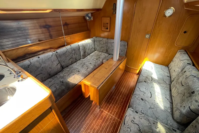 Slide: The Image of Interior of 1988 Beneteau Oceanis 350 sailboat with cozy seating and wooden finishes. - 16