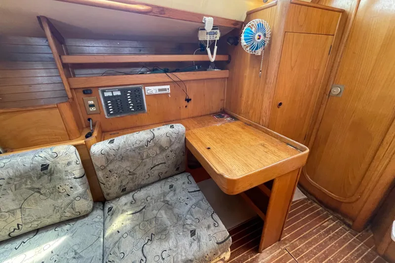 Slide: The Image of Interior of 1988 Beneteau Oceanis 350 sailboat with wooden table and cushioned seating. - 17