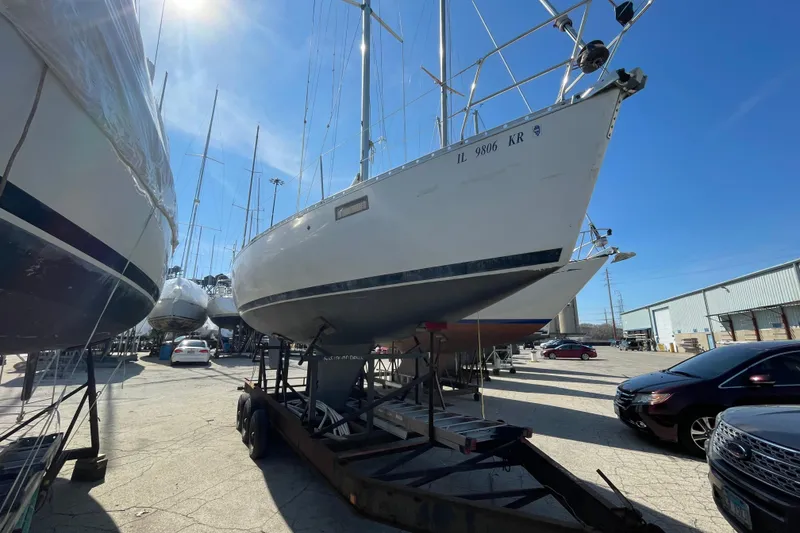 Slide: The Image of 1988 Beneteau Oceanis 350 sailboat on trailer in a marina storage area. - 2