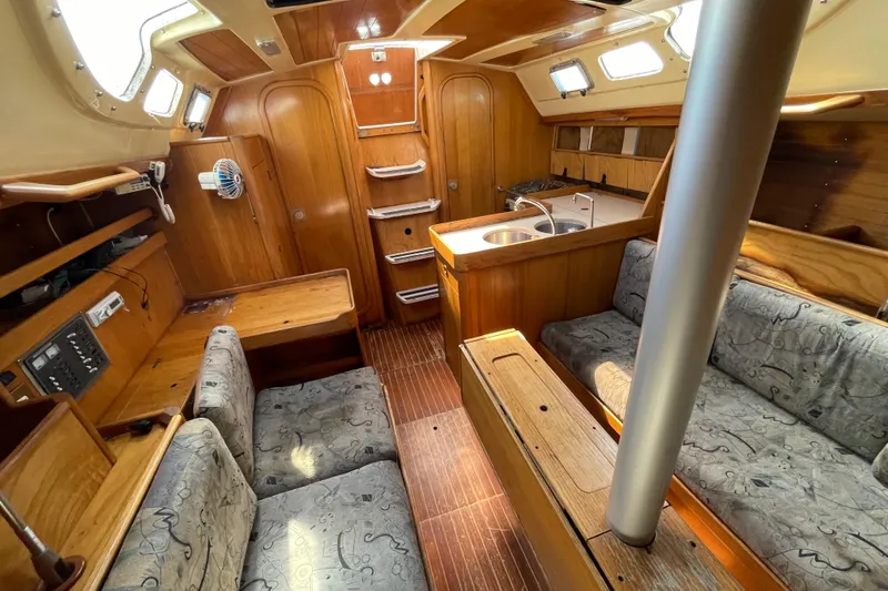 Slide: The Image of Interior of 1988 Beneteau Oceanis 350 sailboat with wood finish and cozy seating area. - 22