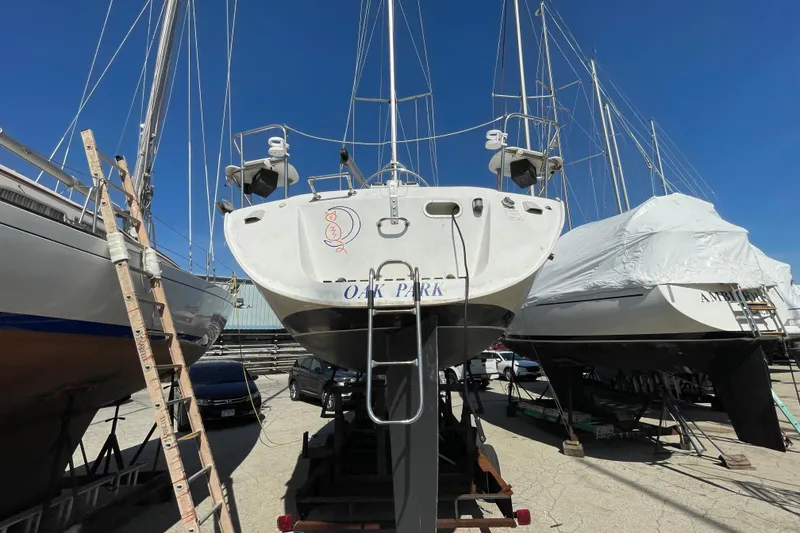 Slide: The Image of 1988 Beneteau Oceanis 350 sailboat on dry dock, surrounded by other vessels. - 5