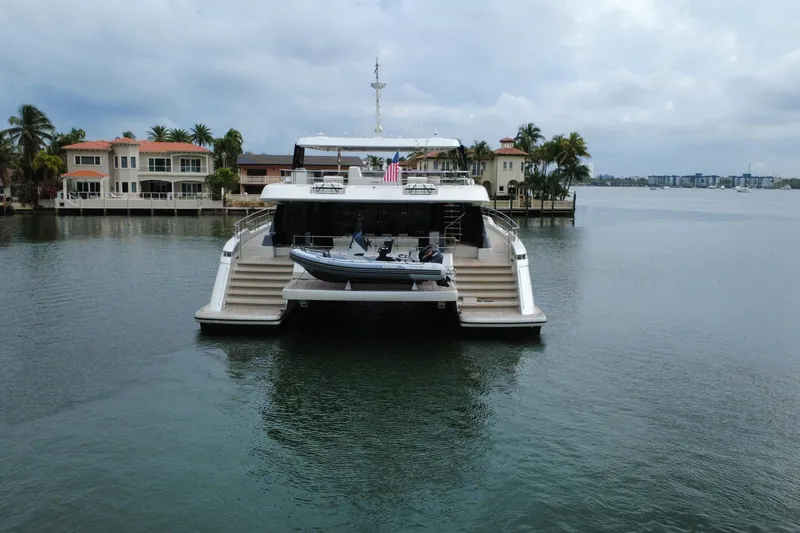 Slide: The Image of 2024 Sunreef 80 Power yacht docked near waterfront homes, featuring a sleek design. - 20
