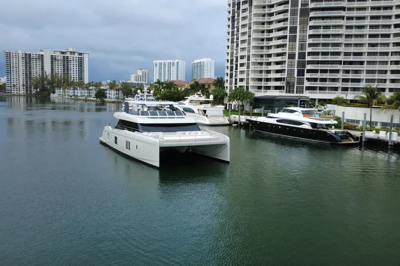 Slide: The Image of Luxurious 2024 Sunreef 80 Power yacht docked near modern waterfront buildings. - 22