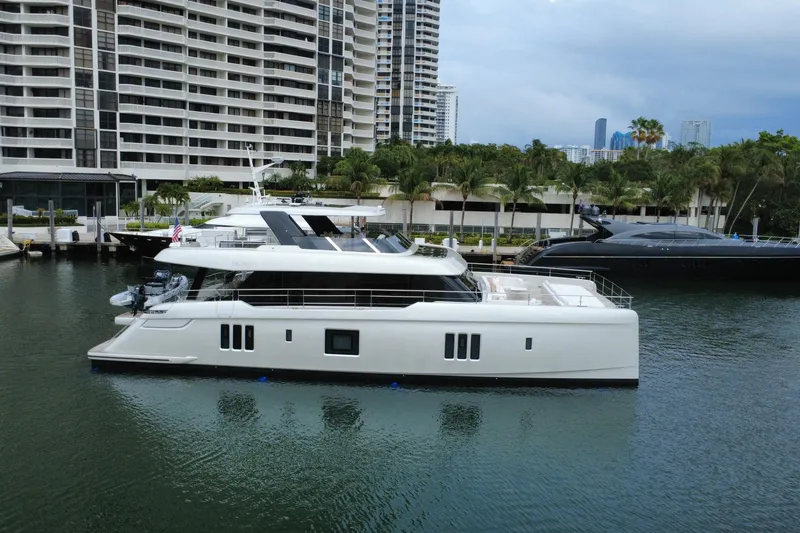 Slide: The Image of 2024 Sunreef 80 Power yacht docked in a marina, surrounded by modern buildings. - 23