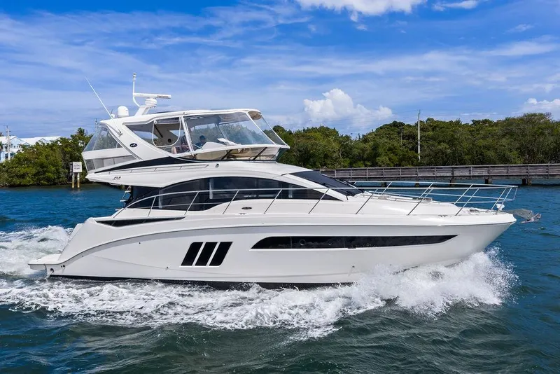 Slide: The Image of 2017 Sea Ray Fly 510 yacht cruising on blue water under a clear sky. - 11