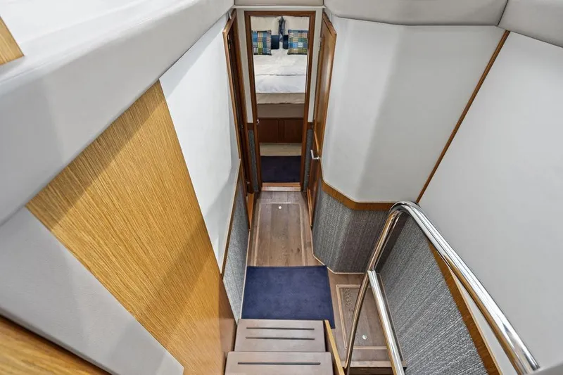 Slide: The Image of Stairway inside 2017 Sea Ray Fly 510 yacht, featuring modern wood and metal design. - 26