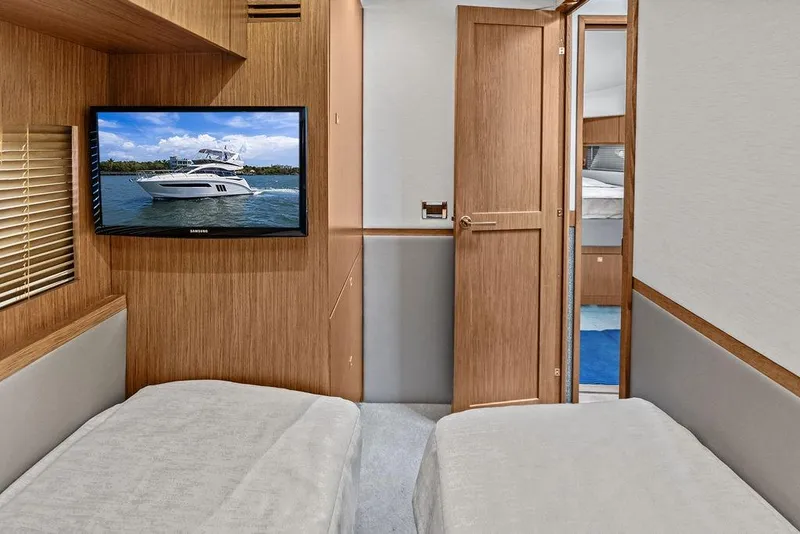 Slide: The Image of Interior of 2017 Sea Ray Fly 510 yacht with twin beds and wall-mounted TV. - 30