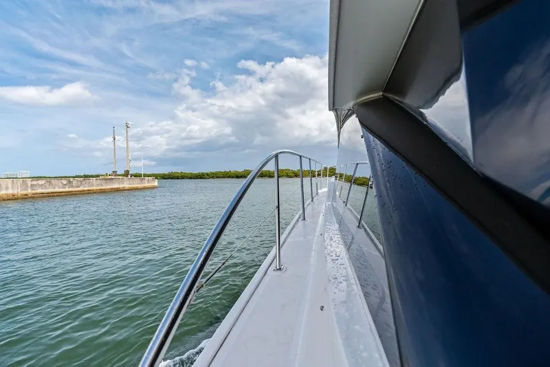 Slide: The Image of 2017 Sea Ray Fly 510 yacht cruising on calm waters under a partly cloudy sky. - 37