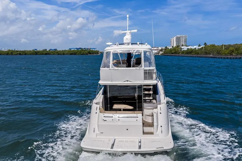Slide: The Image of 2017 Sea Ray Fly 510 yacht cruising on blue water with cityscape background. - 4