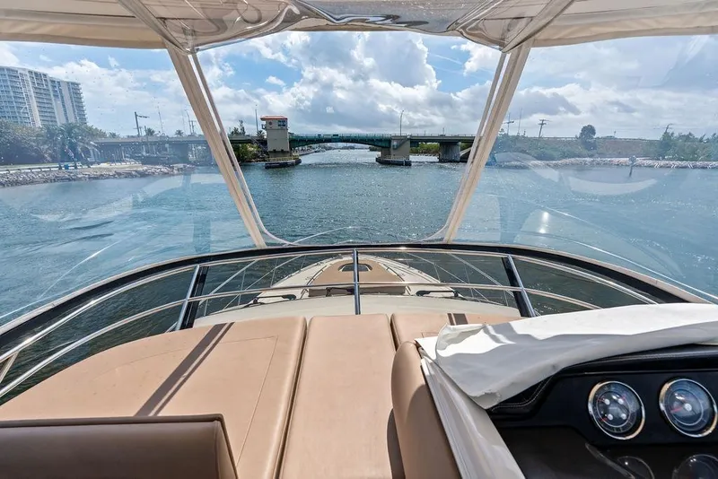 Slide: The Image of 2017 Sea Ray Fly 510 yacht cruising under a sunny sky near a bridge. - 40