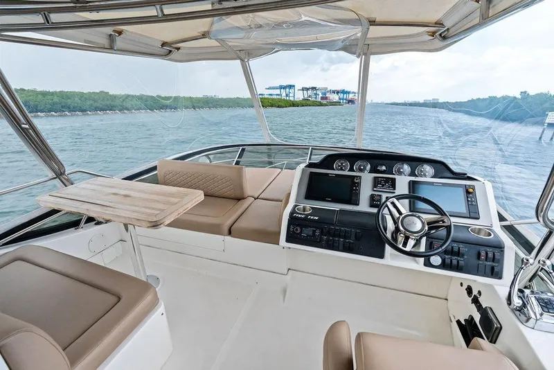 Slide: The Image of 2017 Sea Ray Fly 510 yacht cockpit with modern controls and seating on open water. - 43