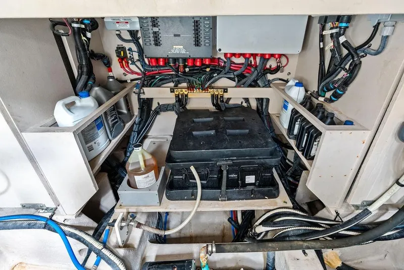Slide: The Image of Engine compartment of a 2017 Sea Ray Fly 510 with wiring and maintenance supplies. - 45