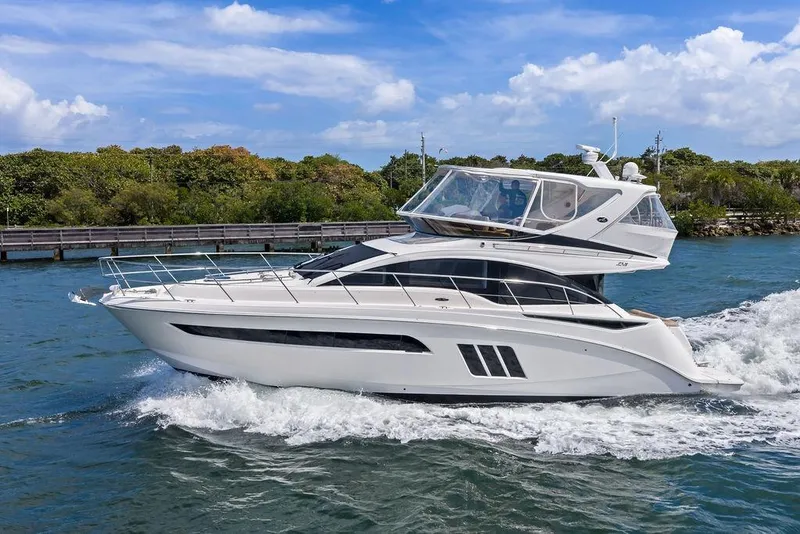 Slide: The Image of 2017 Sea Ray Fly 510 yacht cruising on blue water under a clear sky. - 5