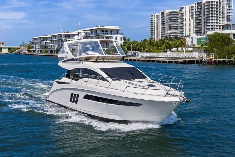 Slide: The Image of 2017 Sea Ray Fly 510 yacht cruising near modern waterfront buildings. - 8