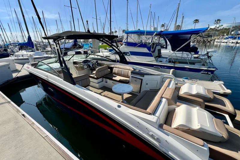 Slide: The Image of 2016 Sea Ray 290 Sundeck Outboard docked in a marina, surrounded by sailboats. - 12