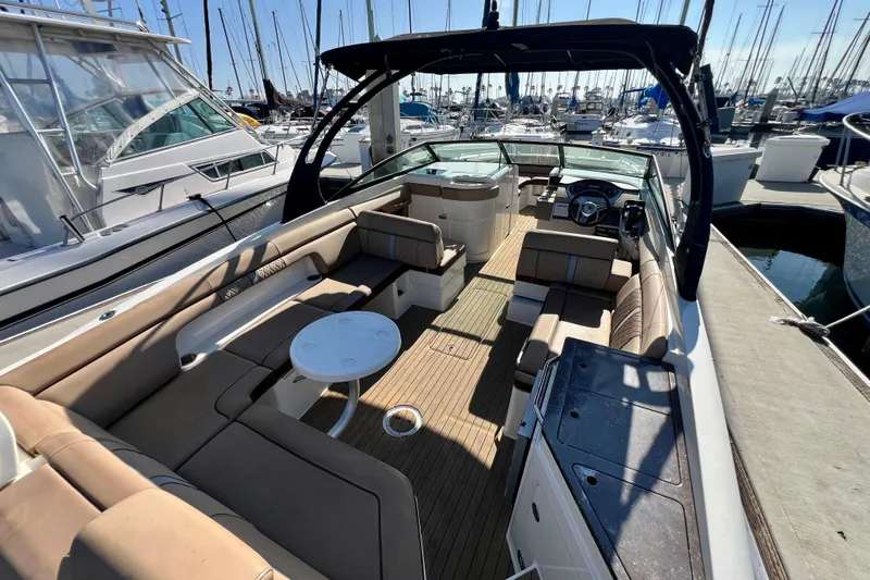 Slide: The Image of 2016 Sea Ray 290 Sundeck Outboard with spacious seating and sleek design in marina. - 13