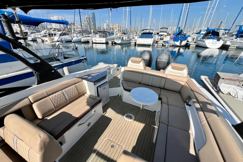 Slide: The Image of 2016 Sea Ray 290 Sundeck Outboard at marina, featuring spacious seating and elegant design. - 14