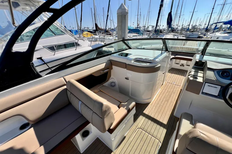 Slide: The Image of 2016 Sea Ray 290 Sundeck Outboard interior with seating and helm, docked at marina. - 17