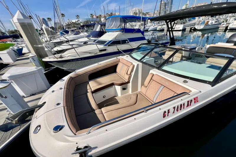 Slide: The Image of 2016 Sea Ray 290 Sundeck Outboard docked in a marina, showcasing luxurious seating. - 2