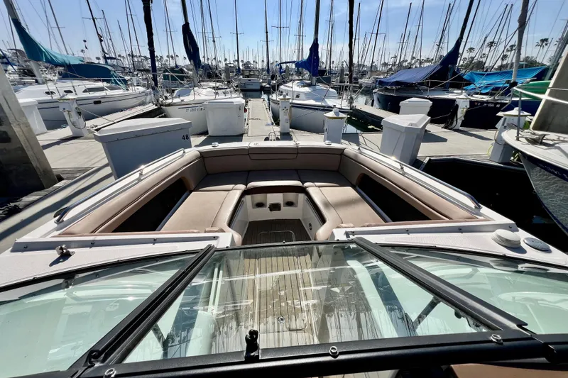 Slide: The Image of 2016 Sea Ray 290 Sundeck Outboard boat docked at marina, surrounded by sailboats. - 22