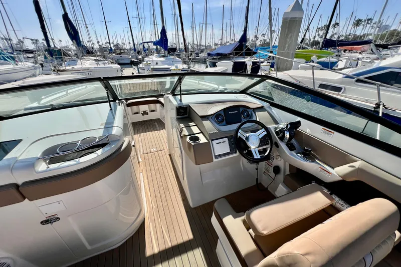 Slide: The Image of 2016 Sea Ray 290 Sundeck Outboard boat interior with helm, docked at marina. - 23
