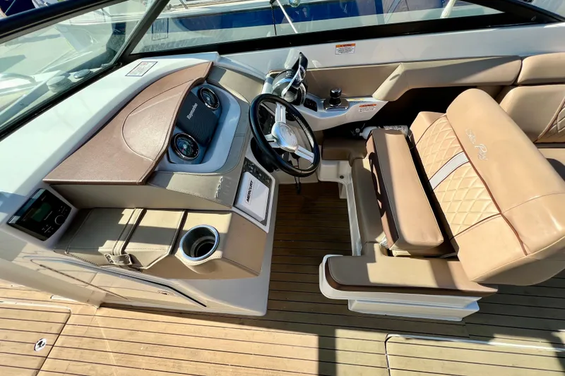 Slide: The Image of 2016 Sea Ray 290 Sundeck Outboard helm with tan seating and modern dashboard. - 25