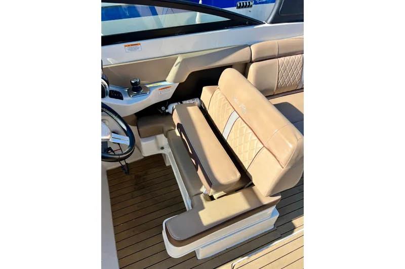 Slide: The Image of 2016 Sea Ray 290 Sundeck Outboard helm with tan leather seating and wood flooring. - 26
