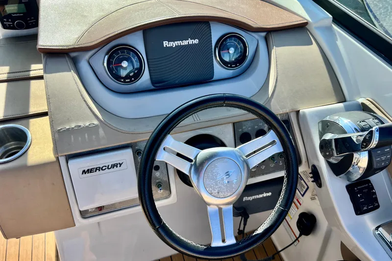 Slide: The Image of 2016 Sea Ray 290 Sundeck Outboard dashboard with Raymarine electronics and Mercury controls. - 27