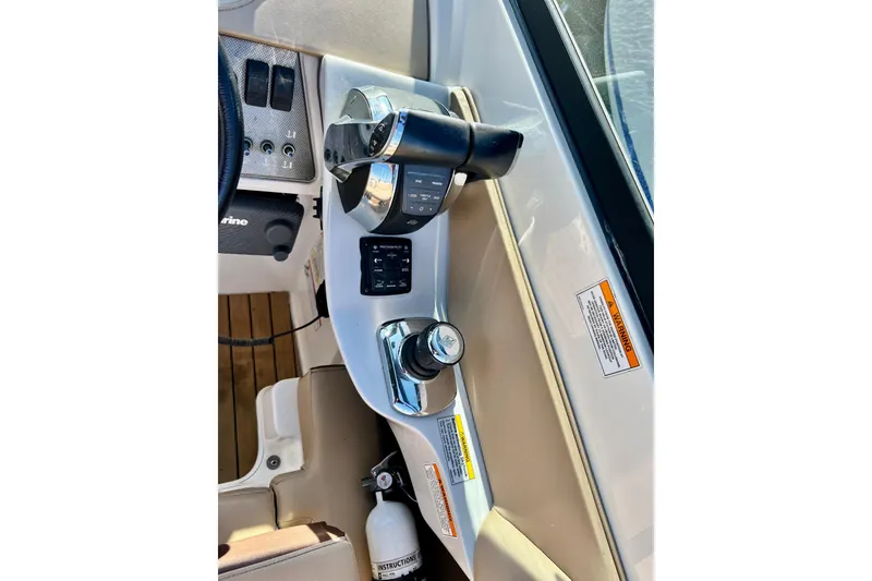 Slide: The Image of 2016 Sea Ray 290 Sundeck Outboard helm controls with throttle and switches. - 29