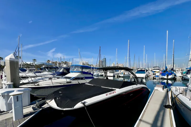 Slide: The Image of Marina with 2016 Sea Ray 290 Sundeck Outboard, surrounded by various boats under clear blue sky. - 3