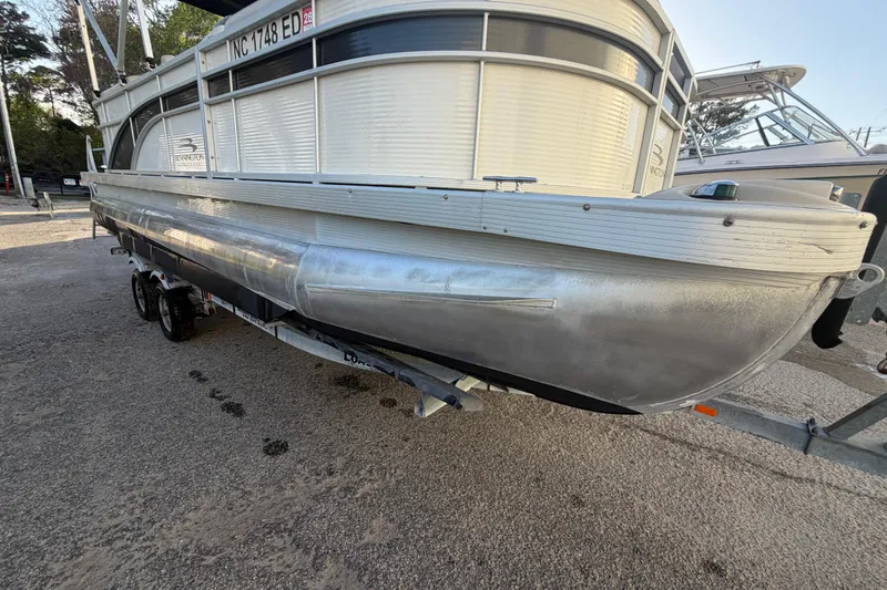 Slide: The Image of 2016 Bennington 22 SX pontoon boat on trailer, parked outdoors. - 15
