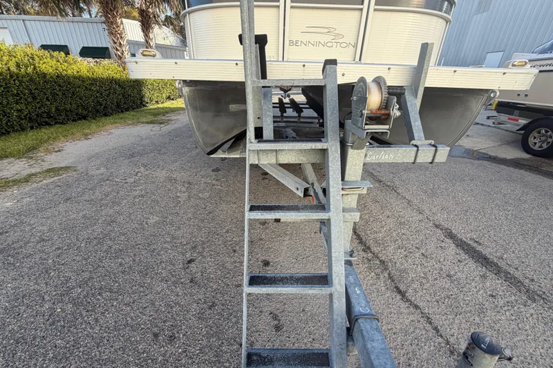 Slide: The Image of 2016 Bennington 22 SX pontoon boat on trailer with metal ladder. - 17