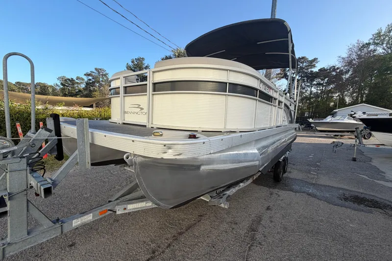Slide: The Image of 2016 Bennington 22 SX pontoon boat on trailer, parked outdoors. - 21