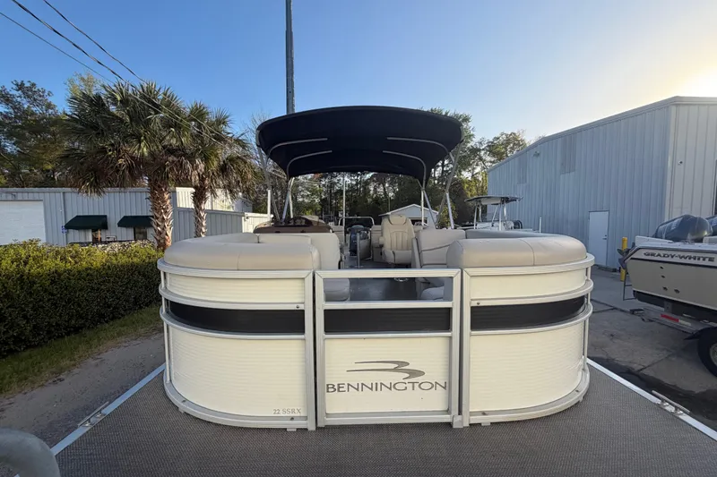 Slide: The Image of 2016 Bennington 22 SX pontoon boat parked outdoors near palm trees and buildings. - 24