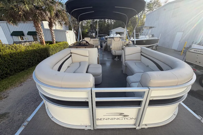 Slide: The Image of 2016 Bennington 22 SX pontoon boat with beige seating and canopy. - 25