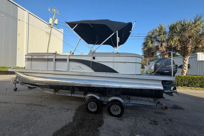 Slide: The Image of 2016 Bennington 22 SX pontoon boat on trailer, with canopy and Yamaha outboard motor. - 26