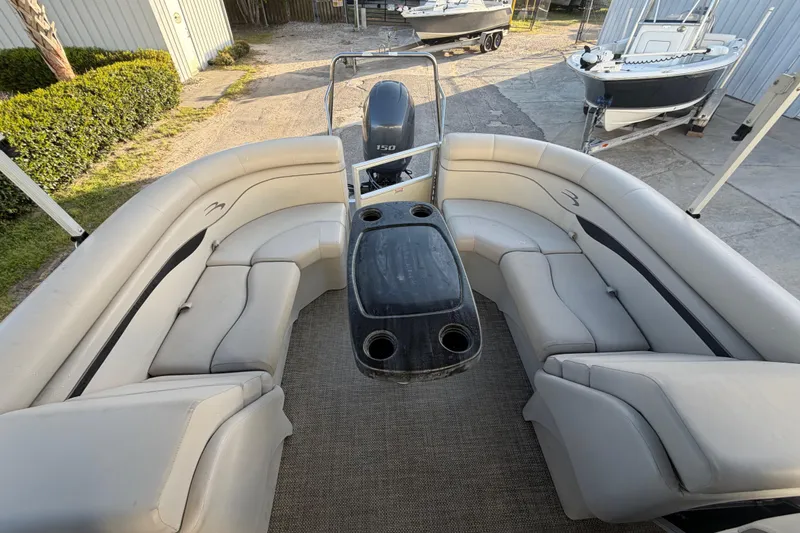 Slide: The Image of 2016 Bennington 22 SX pontoon boat interior with beige seating and central table. - 33