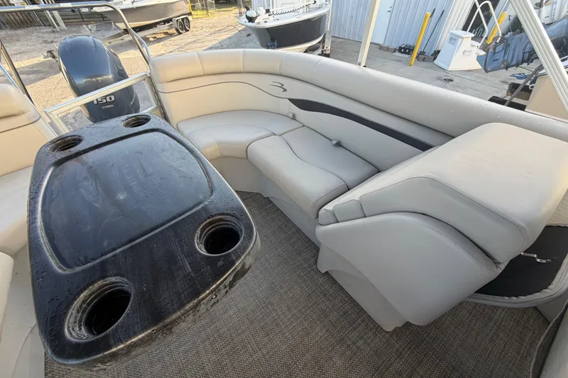 Slide: The Image of 2016 Bennington 22 SX pontoon boat interior with seating and table, featuring cup holders. - 34